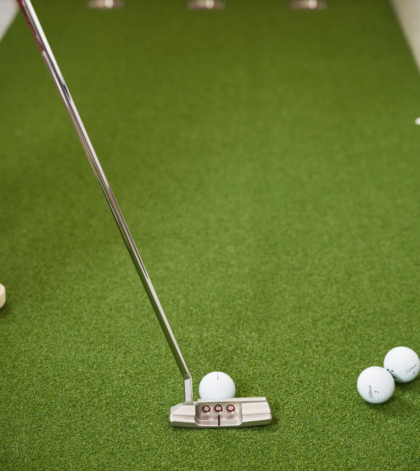 Putter and golf ball on a backyard putting green